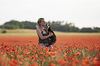 woman with Border Collie in the poppy field