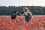 woman with Border Collie in the poppy field