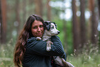 Woman carries Miniature American Shepherd