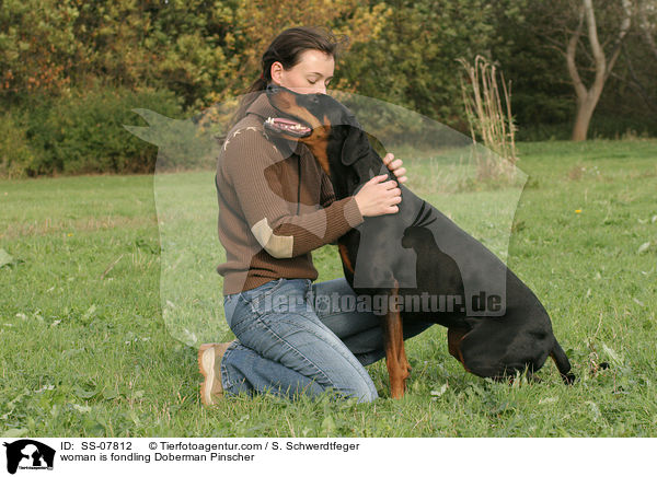 Frau kuschelt mit Dobermann / woman is fondling Doberman Pinscher / SS-07812