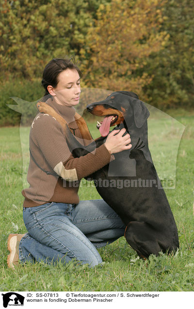 Frau kuschelt mit Dobermann / woman is fondling Doberman Pinscher / SS-07813