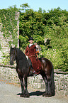 horsewoman with friesian horse and hawk