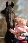 woman, child and Friesian horse