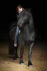 woman rides Frisian horse