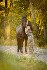 young woman with friesian mare