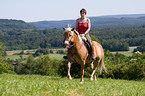 woman rides Haflinger horse