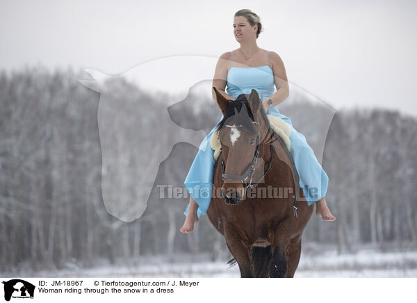 Woman riding through the snow in a dress / JM-18967