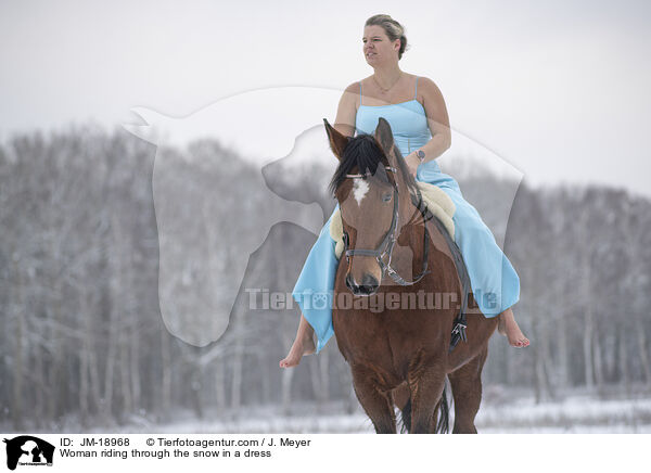 Woman riding through the snow in a dress / JM-18968